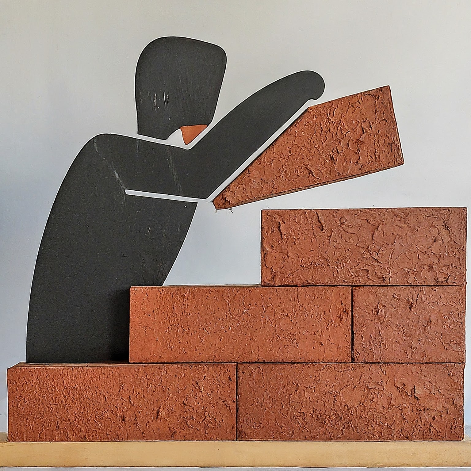 Man building a wall brick by brick